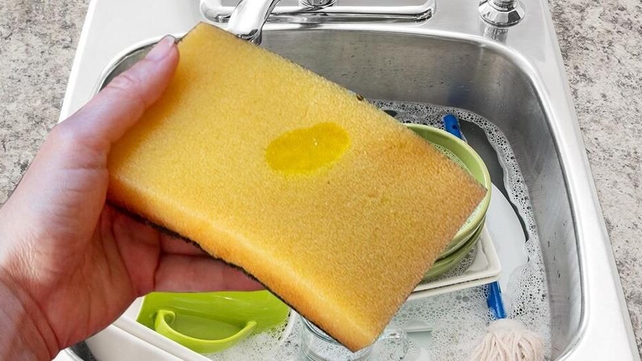 Spugna con pallina di sapone giallo pronta per essere usata sui piatti